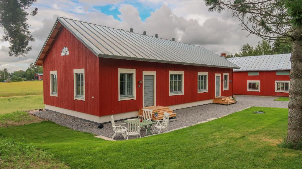 VöyriLillstugans Gästhem BnB的前面的红色谷仓,设有野餐桌