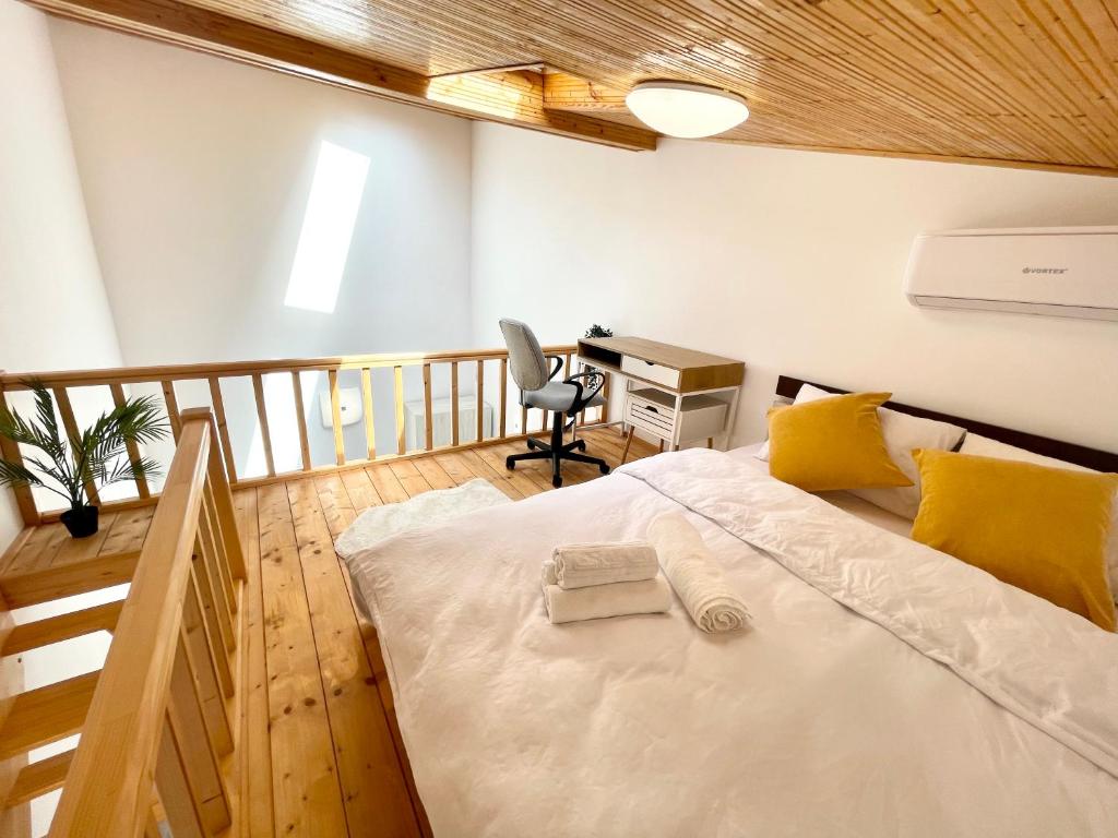 布加勒斯特The Loft的一间卧室配有一张带桌子和椅子的床