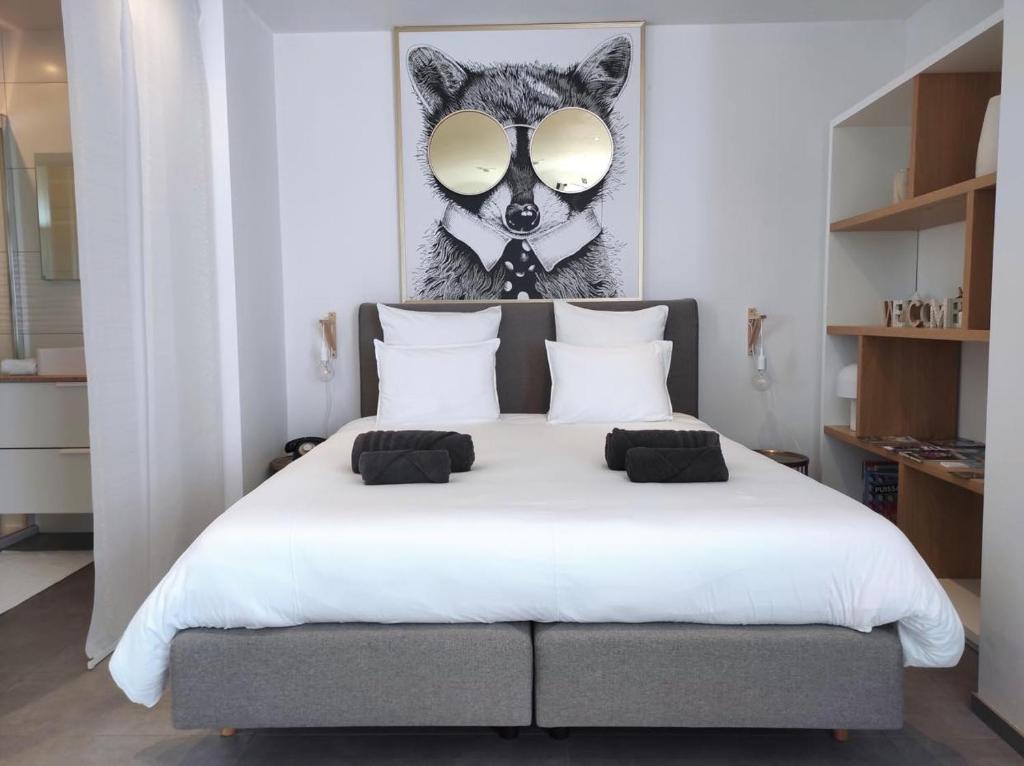 LierneuxLa planque du raton laveur的卧室配有一张白色床,墙上挂着狼的照片