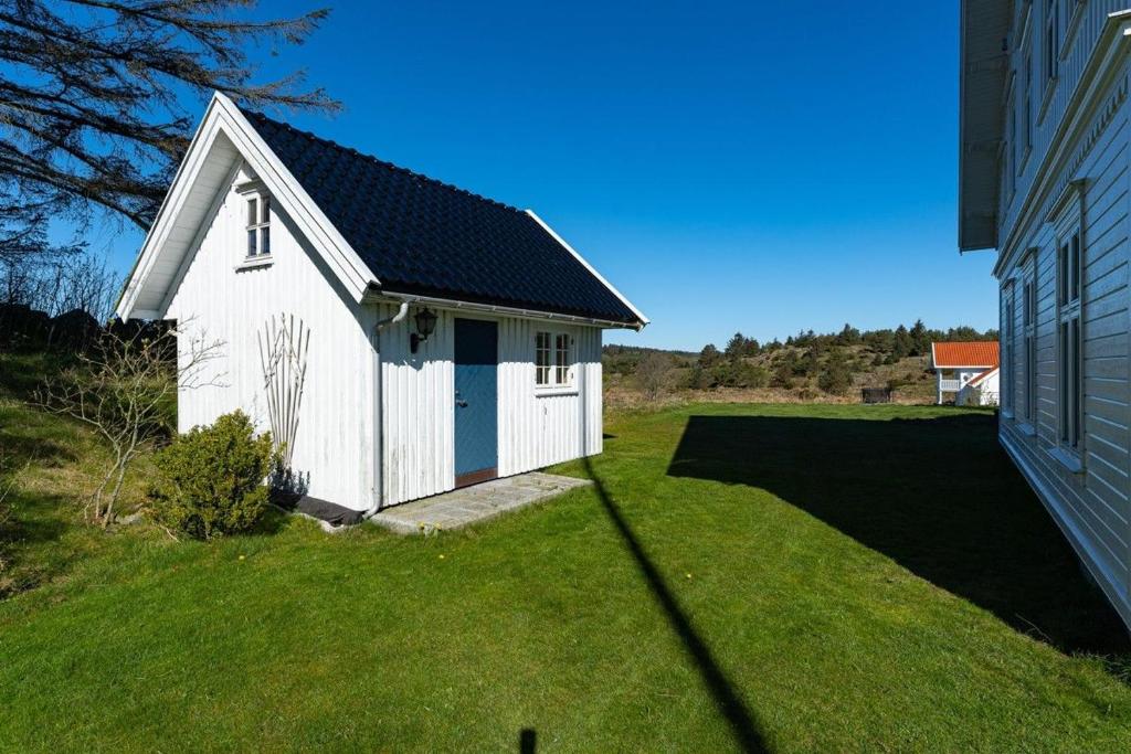 法尔松Villa Krågenes的一座小白色建筑,位于房子旁边的院子内
