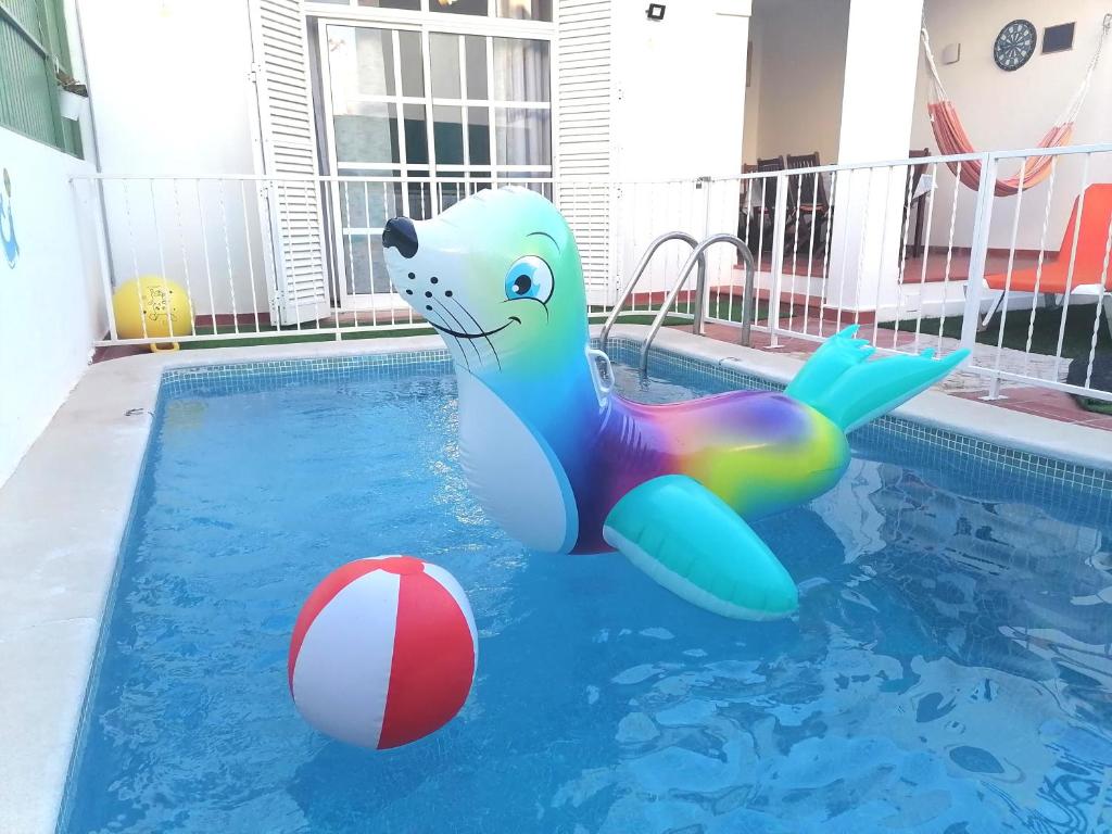 拉戈斯Marreiro's house Algarve - Child friendy - Private Pool的海豚充气在带有球的游泳池里