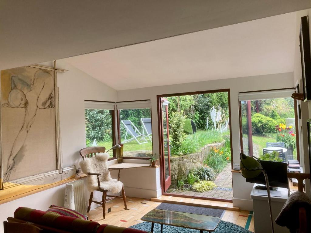 PewseyUnique Artists studio with a private garden.的客厅设有桌子和窗户。