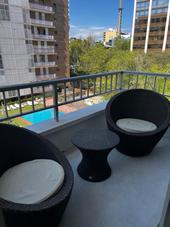 巴塞罗那Precioso y tranquilo apartamento zona alta Diagonal Barcelona的阳台配有两把椅子、浴缸和一张桌子。