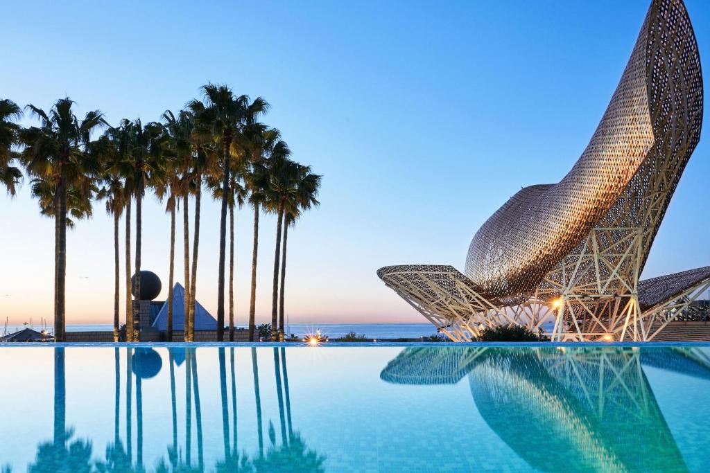 巴塞罗那巴塞罗那艺术酒店的享有带游泳池和棕榈树的度假村的景致