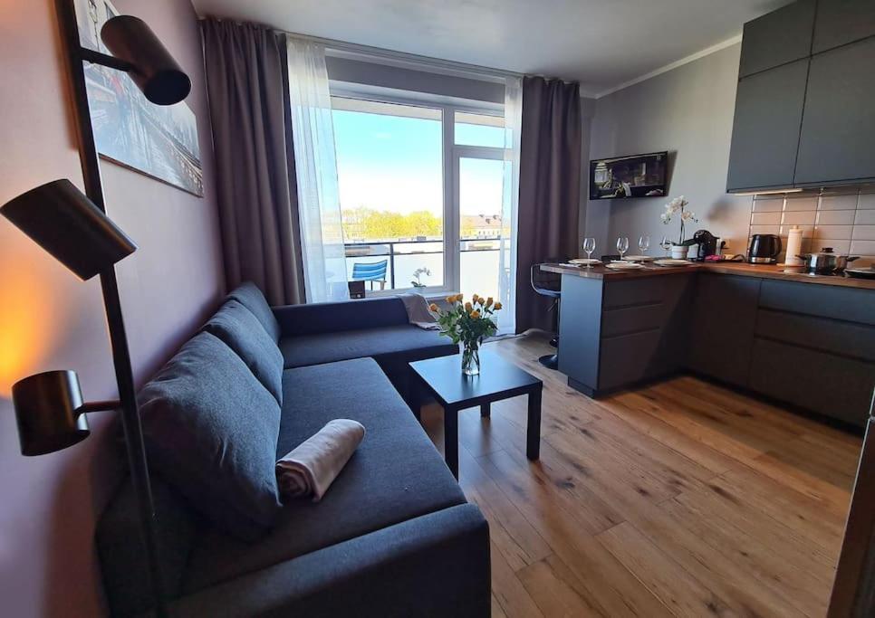里加Stylish apartment with parking & spacious balcony的一间带蓝色沙发的客厅和一间厨房
