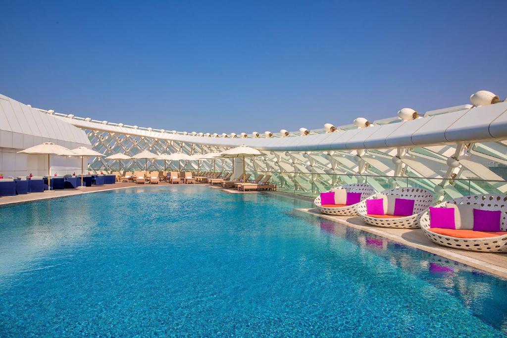 阿布扎比W Abu Dhabi - Yas Island的一座游泳池,里面设有五颜六色的椅子