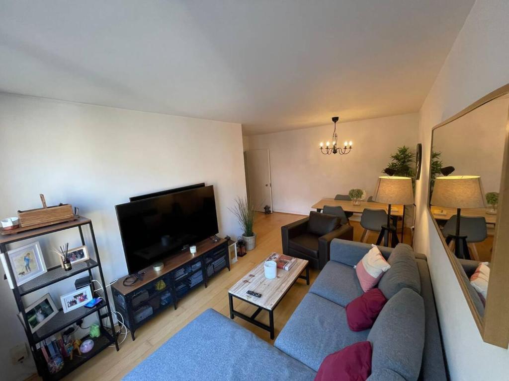 伦敦Refurbished central apartment的客厅配有蓝色的沙发和电视