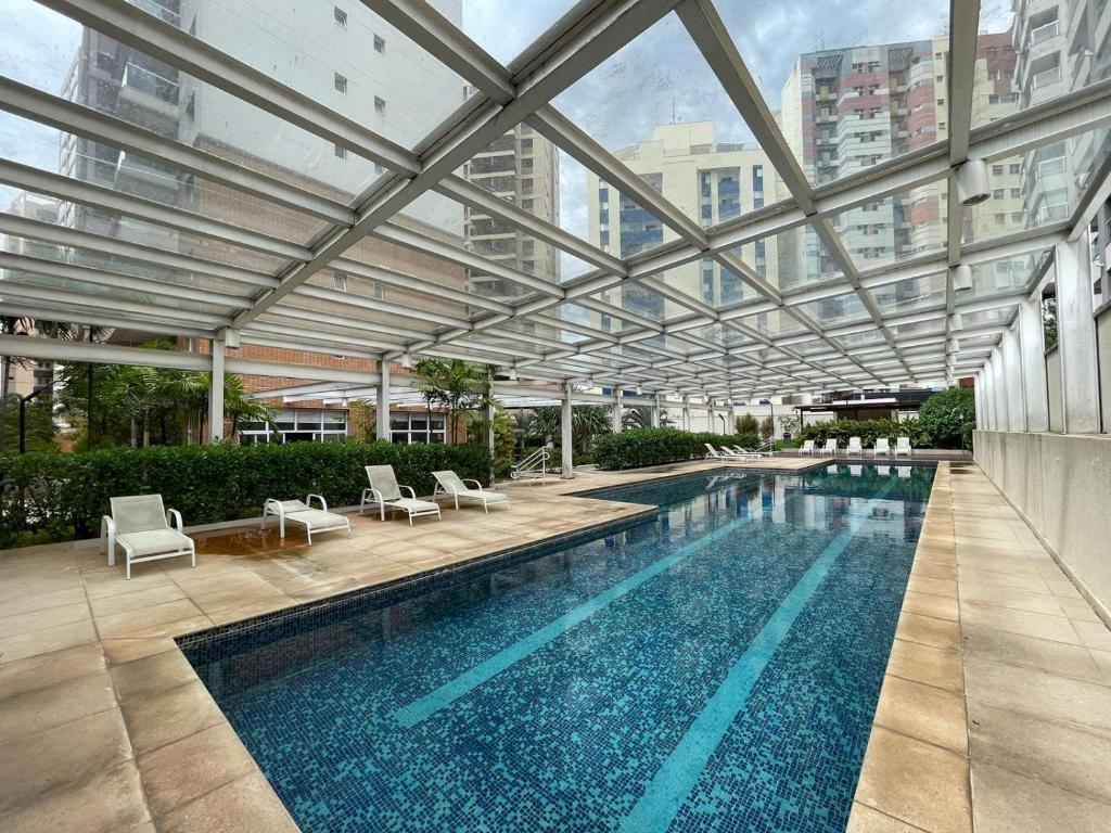 坎皮纳斯Studio Deluxe - Dot 173的一个带玻璃天花板的大型游泳池