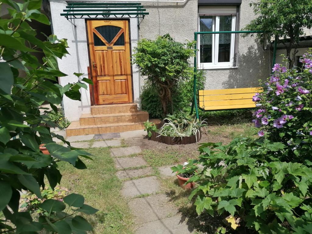 克塞洛Hanna 3 Apartman的一座带木门和黄色长凳的房子
