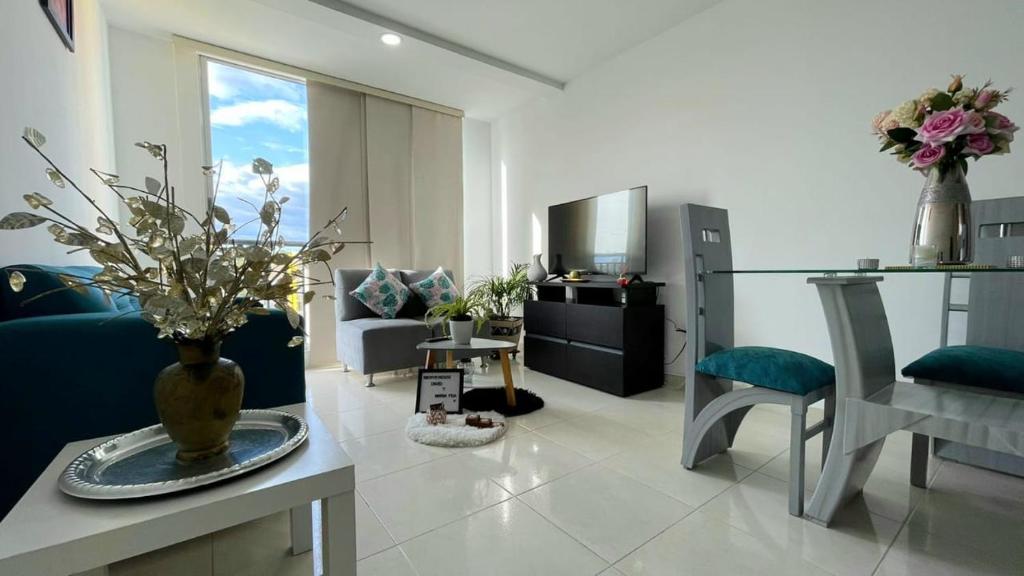 内瓦CB Somos AT HOME Apto cómodo e impecable con Aire Acondicionado的客厅,桌子上放着花瓶
