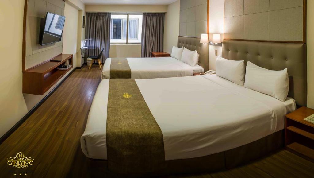 利马Hotel Candamo的酒店客房设有两张床和电视。