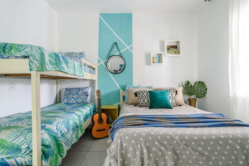 帕罗卡Pinheira Beach House com Jacuzzi的一间卧室设有两张双层床和吉他。