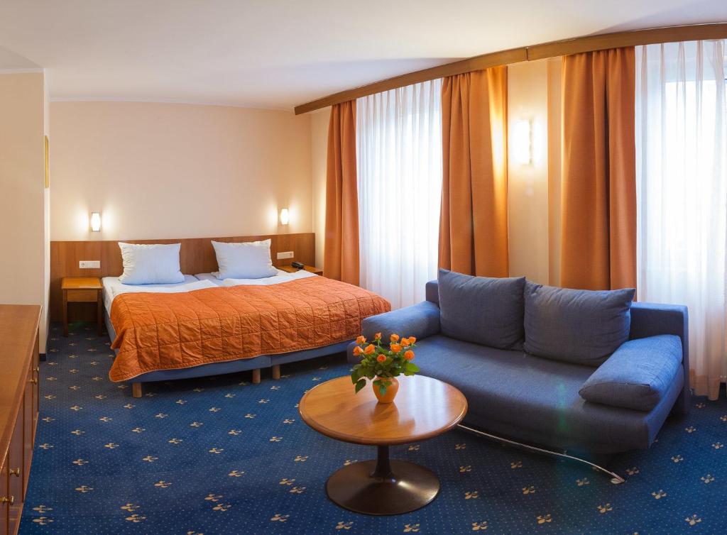 杜塞尔多夫鲁宾酒店的酒店客房,配有床和沙发