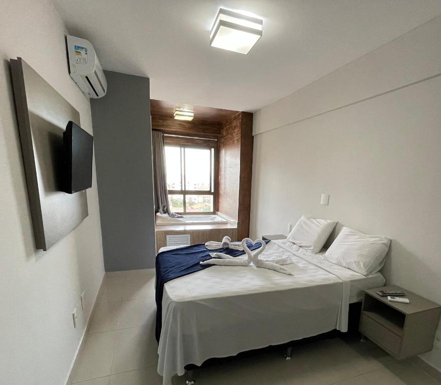 阿拉卡茹DUPLEX com Hidromassagem total de 02 QUARTOS e Vista MAR的小房间设有一张带窗户的床
