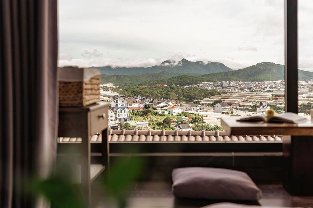 胡志良Miền Sương Khói - Home & Café的享有城市和山脉景致的窗户。