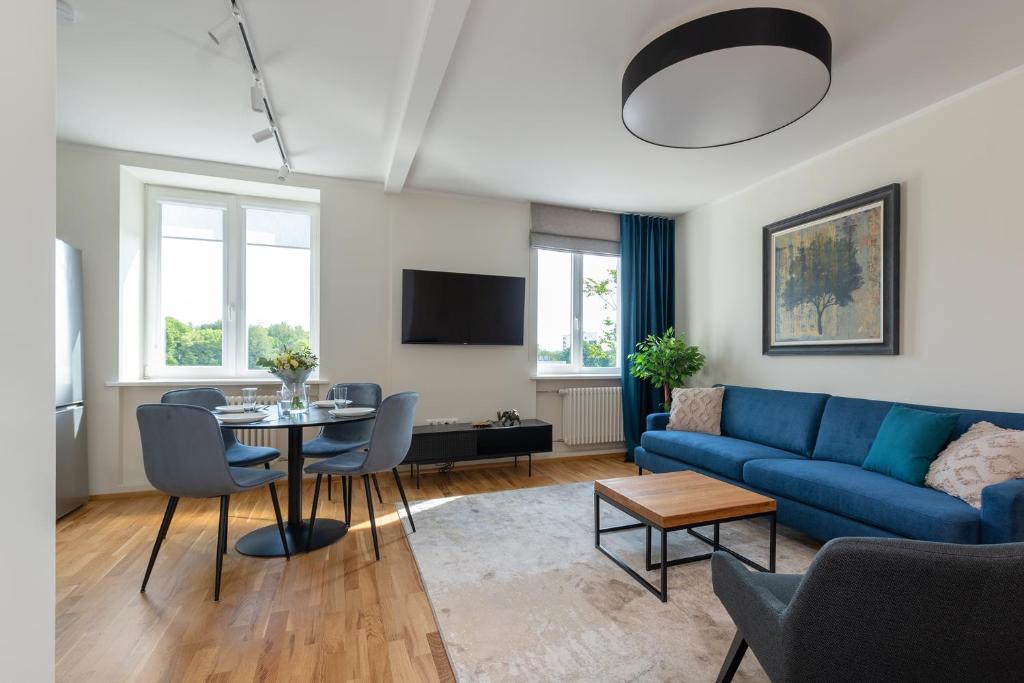 塔尔图Old town luxury penthouse apartment with Emajõgi view的客厅配有蓝色的沙发和桌子