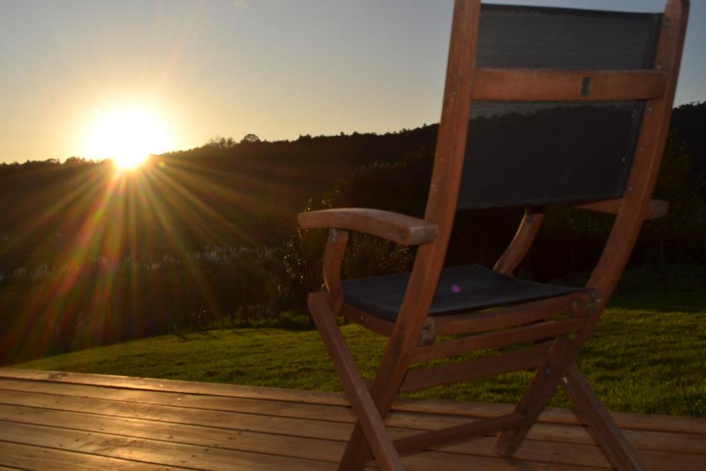 KaukapakapaManuka Views - Close to Thermal Hot Pools的木椅,坐在甲板上,欣赏日落