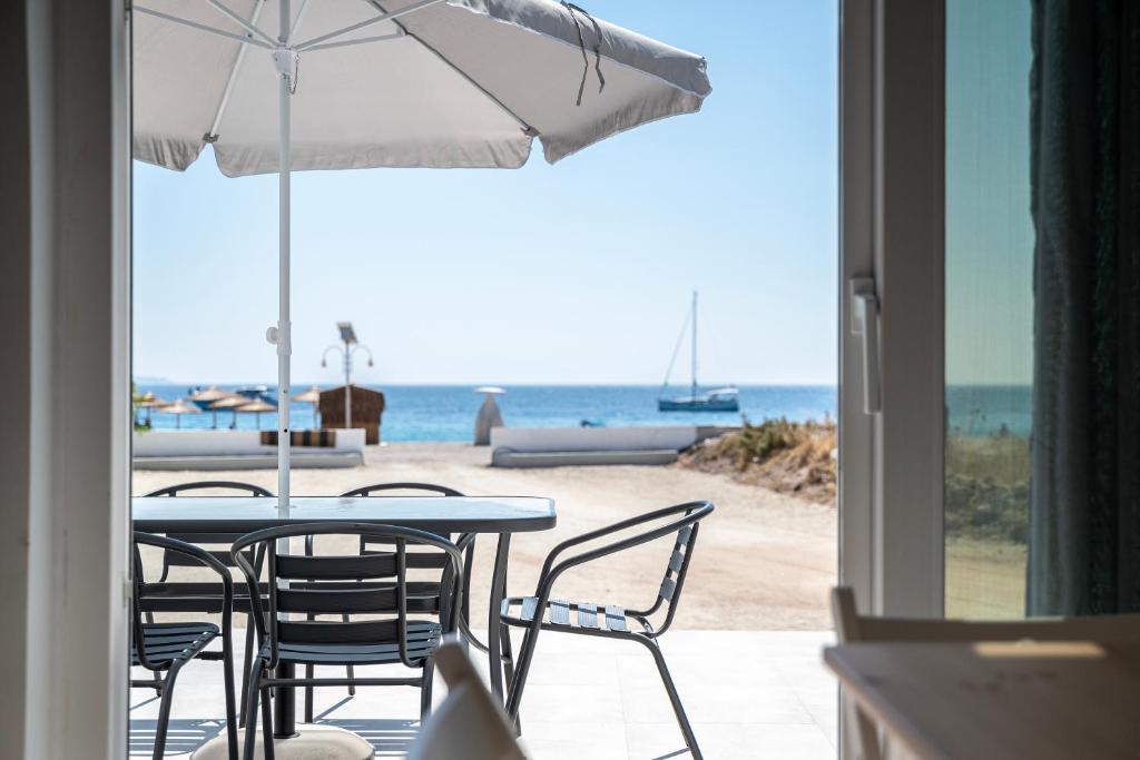 凯法洛斯Thalassa Beach House的海滩上的桌椅和遮阳伞