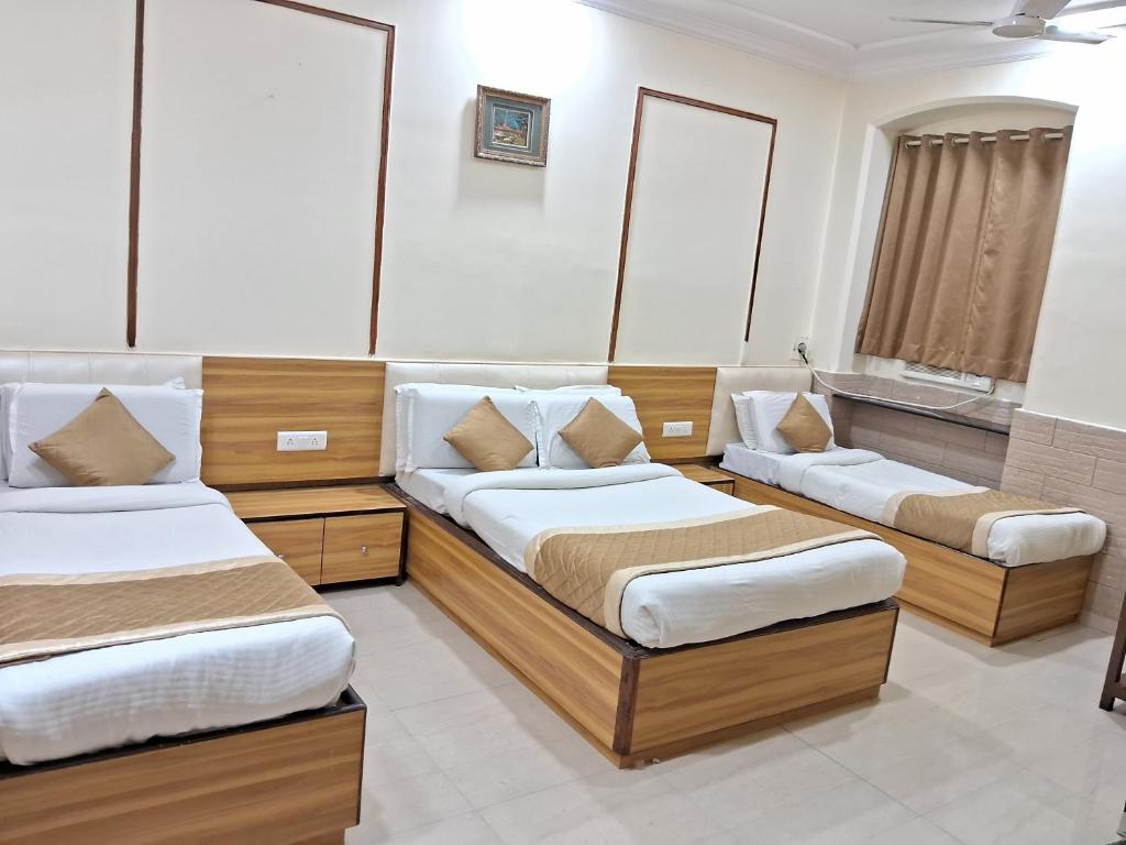 孟买Swapna International的带三张床和浴缸的客房