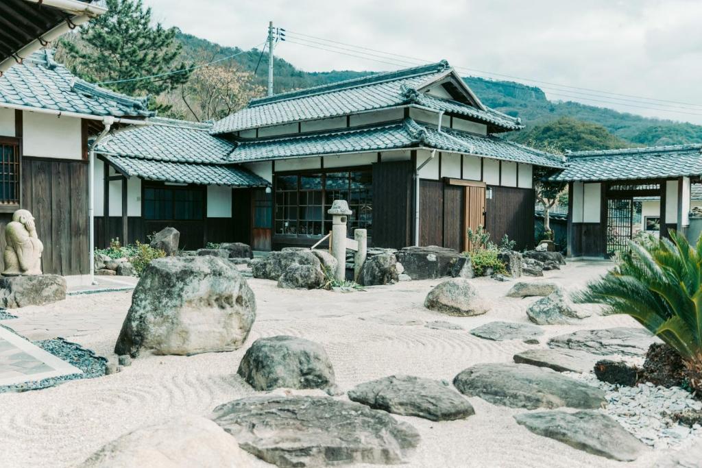 IeuraTokuto"Queen Villa" - Vacation STAY 81603v的一座建筑前有岩石的寺庙