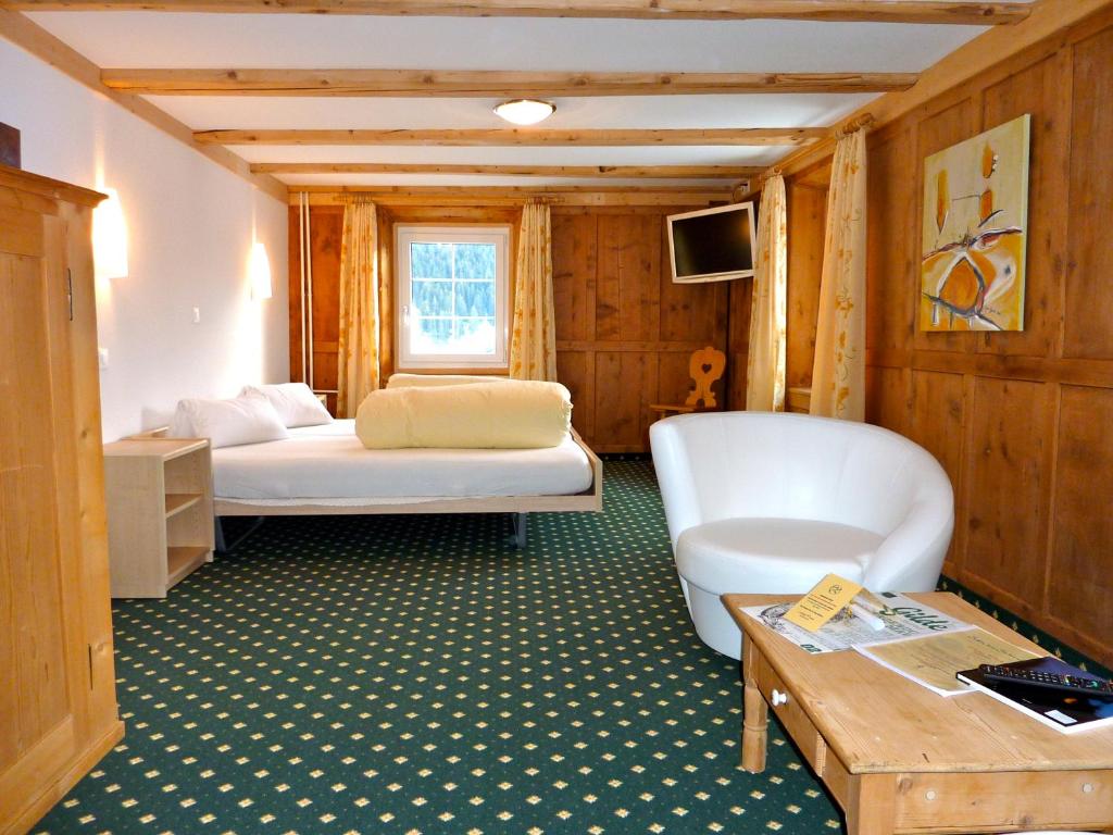 塞德龙波斯塔酒店的客厅配有两张床和一张桌子