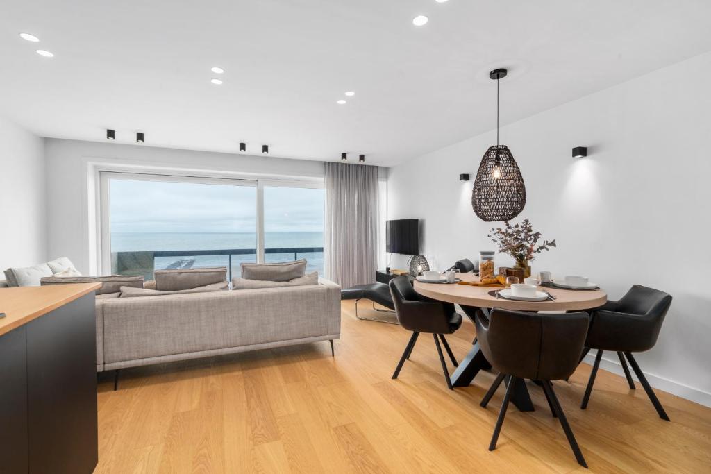 米德尔克尔克Dune Rose - flat with frontal sea view的客厅配有桌子和沙发