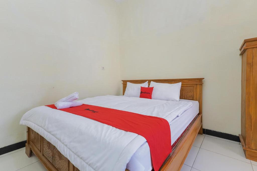 岩望RedDoorz Syariah near Alun Alun Pasuruan的一间卧室配有一张带红色毯子的大床