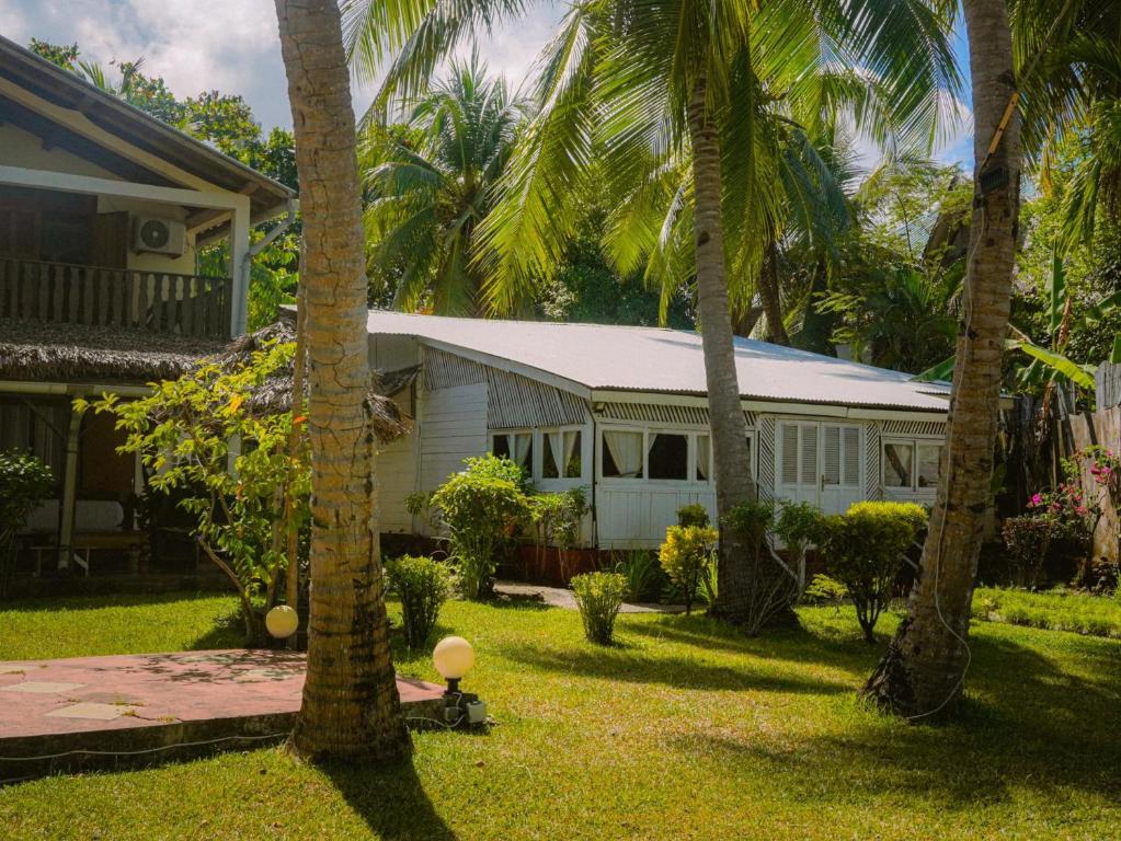 贝岛Villa Tsara - Vacances de rêve à la mer的一座棕榈树的白色房子