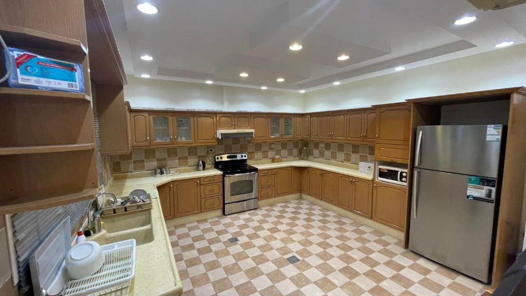 Madīnat Yanbu‘ aş Şinā‘īyahH5-hاتش5的厨房配有木制橱柜和不锈钢冰箱。