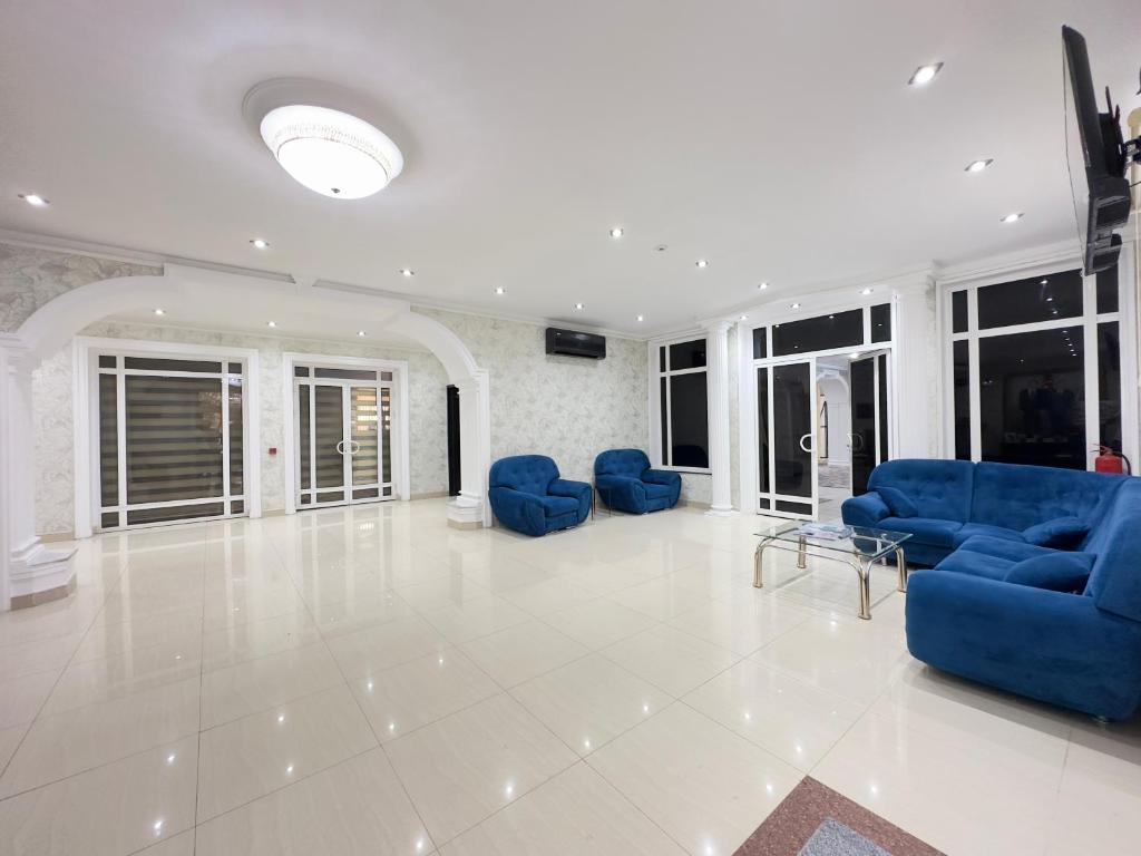 巴库RoseMary Inn的大型客厅设有蓝色的沙发和窗户。