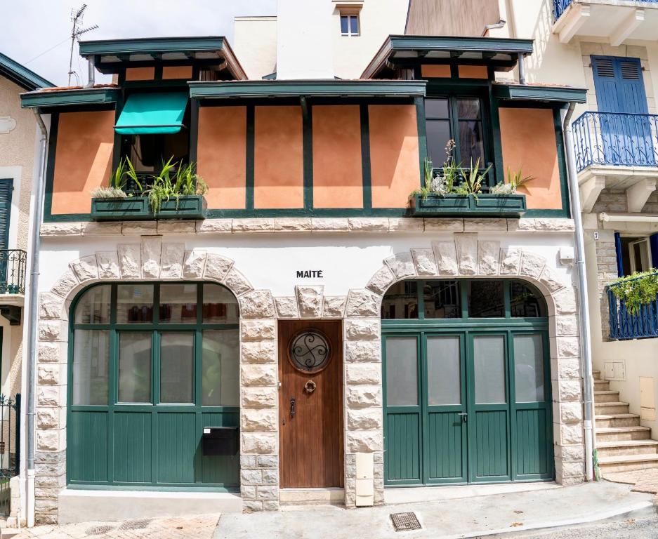 比亚里茨Maison MAÏTÉ, au cœur de Biarritz的一座带绿门和窗户的建筑
