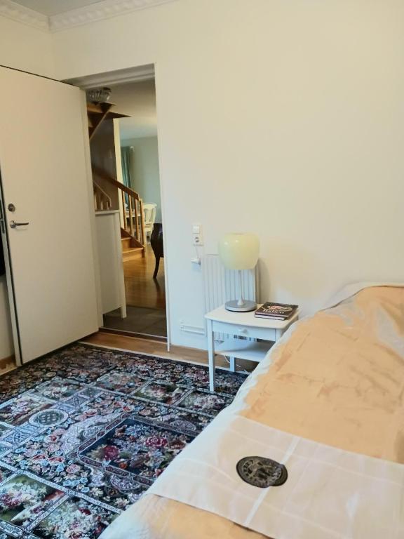 乌普萨拉Villa Herrhagen的一间卧室配有一张床和一张桌子,铺有地毯