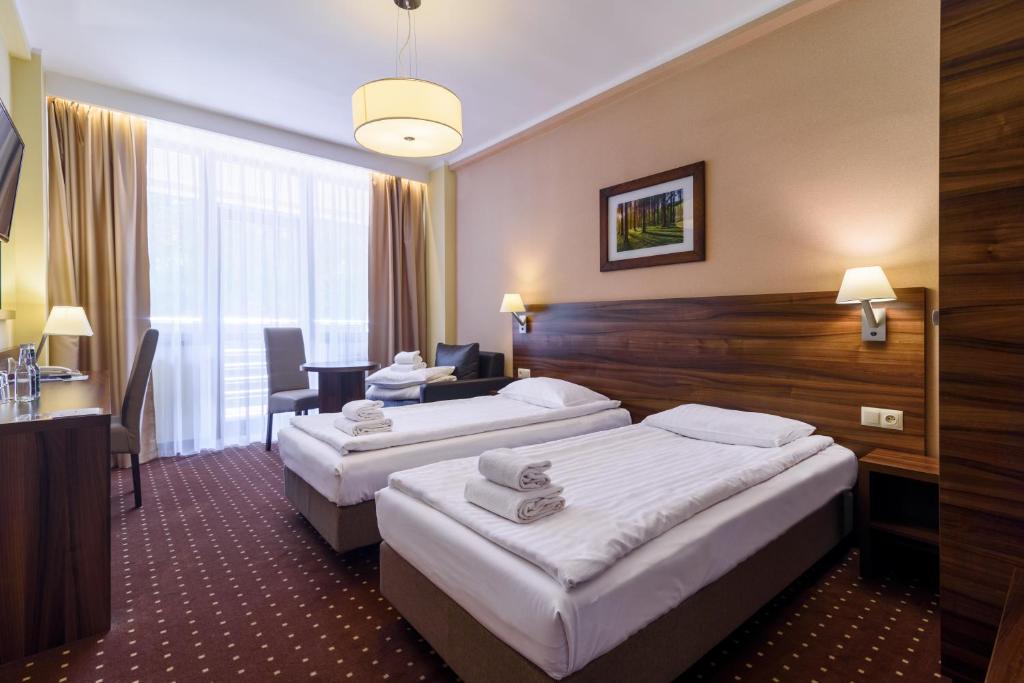 维斯瓦波迪乌姆酒店的酒店客房配有两张床和一张书桌