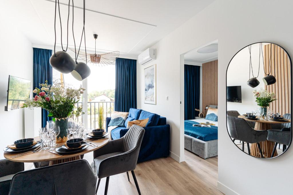 格但斯克Baltic Residence by LoftAffair的客厅配有桌子和蓝色沙发