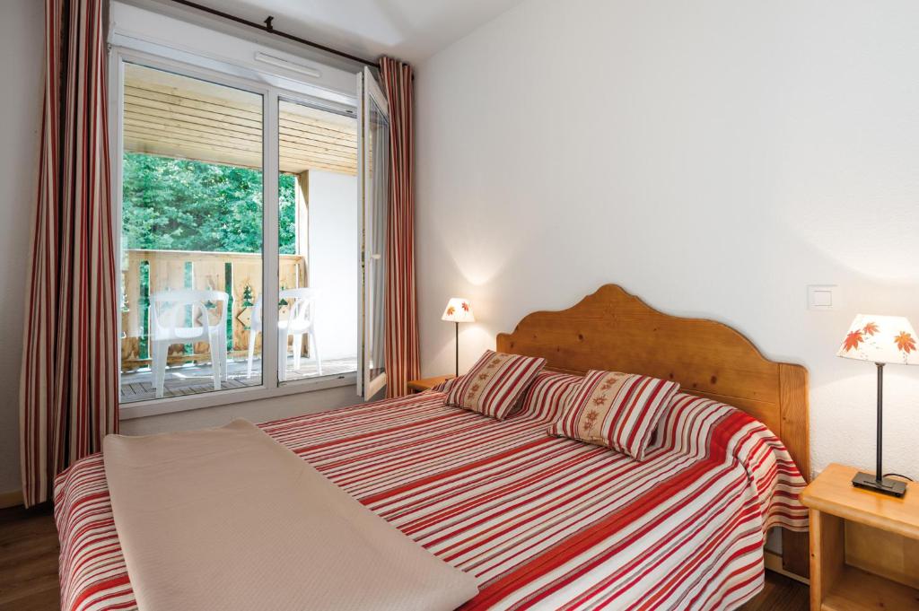 科特雷Lagrange Vacances Le Domaine des 100 Lacs的一间卧室设有一张床和一个大窗户