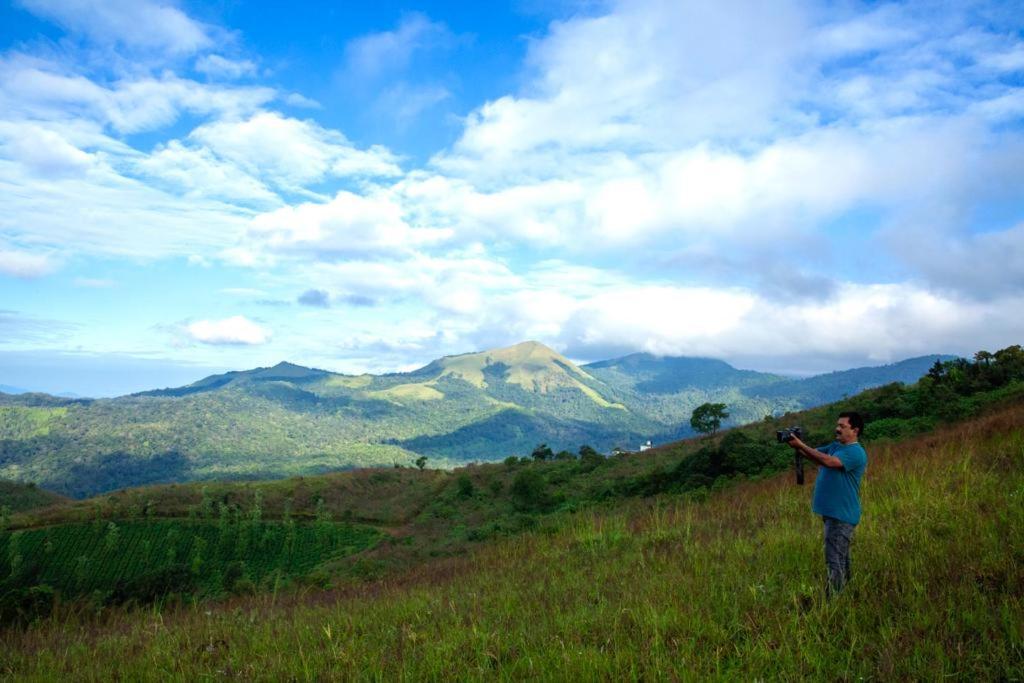 TindummalThe Forest Resort - Muneeswaramudi Eco Hermitage and Farms的站在山丘上望着山 ⁇ 的人