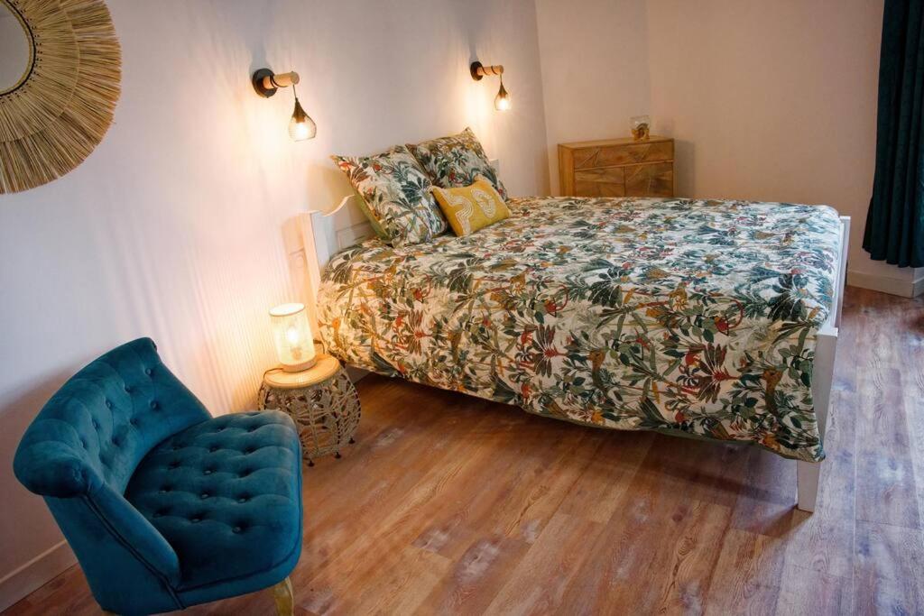 Thorée-les-PinsLa Thorésienne的一间卧室配有一张床和一张蓝色椅子