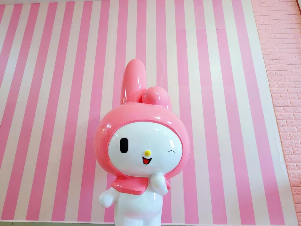 普崇Puchong HELLO KITTY FULLY AIR-CON Suite的一只玩具兔子站在粉红色的墙上