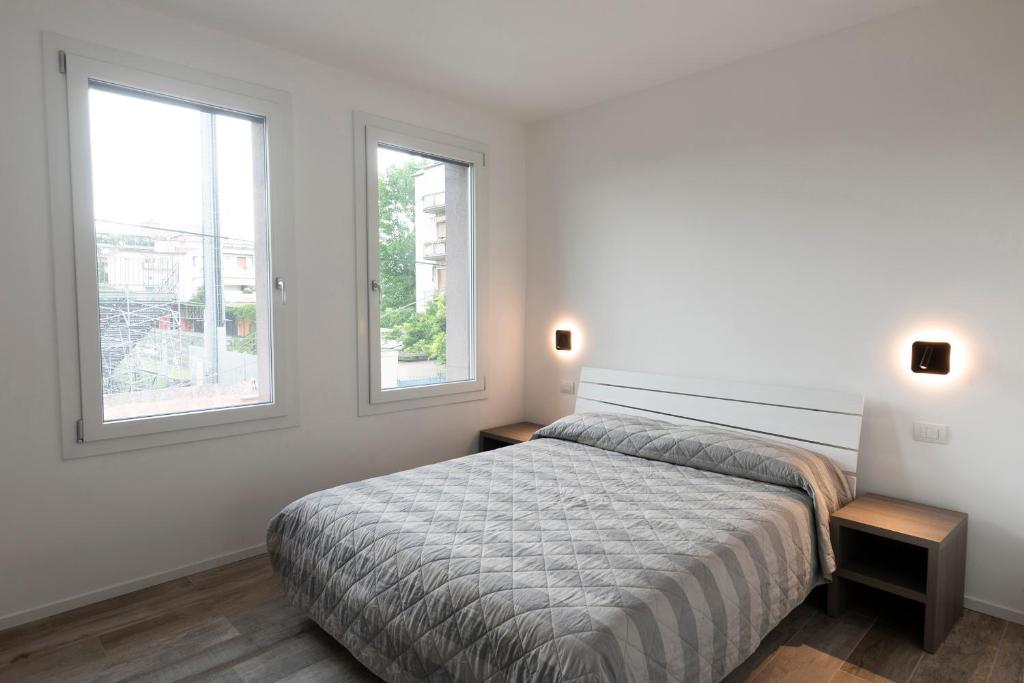 梅斯特Residence Cavalli的一间白色卧室,配有床和2个窗户