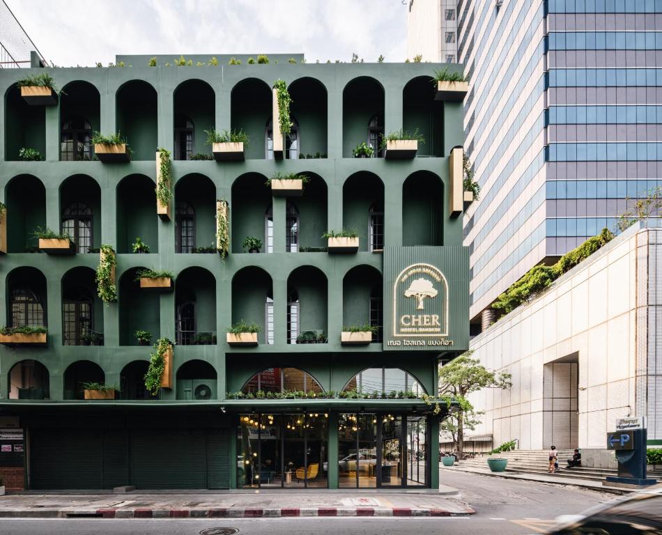 曼谷Cher Hostel Bangkok的绿色建筑的侧面有标志