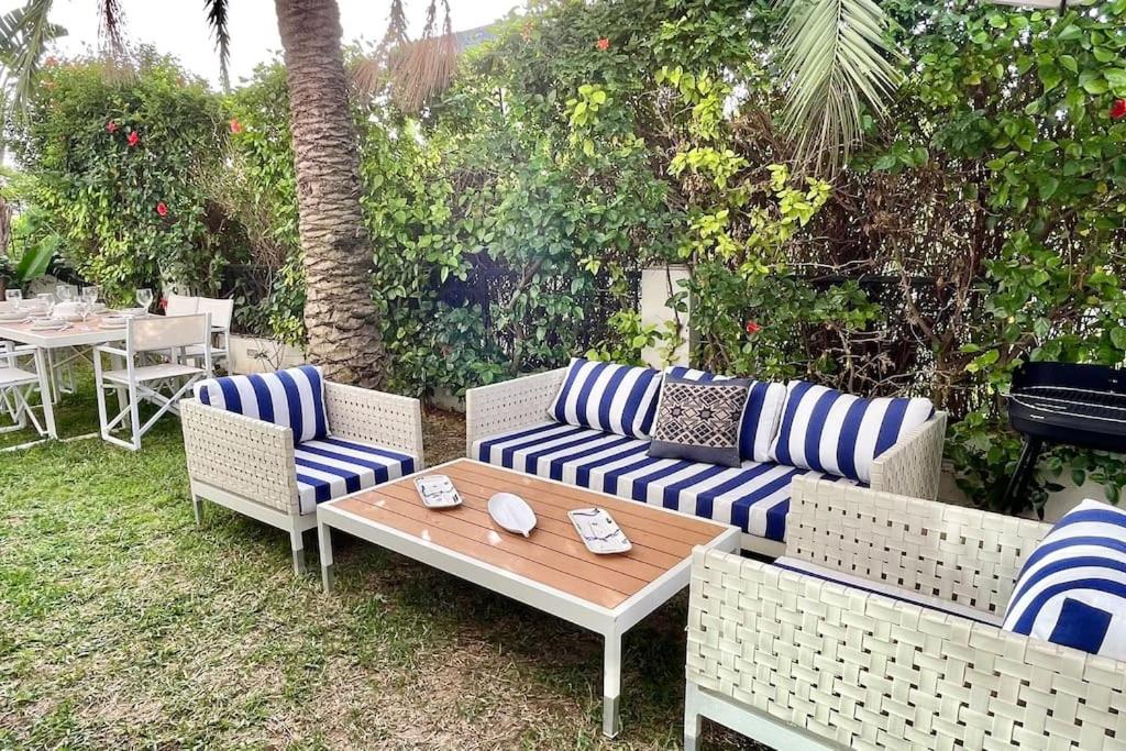 拉马萨Sindbad House的庭院配有蓝白色条纹沙发和桌子