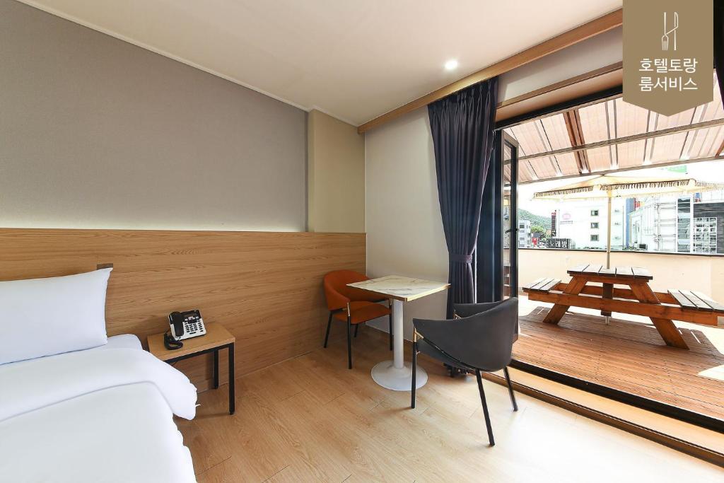 全州市Hotel Torang Jeonju的一间卧室配有一张床、一张书桌和一个窗户。