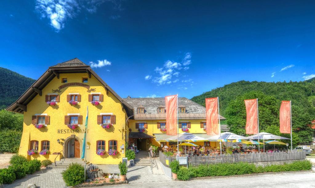 魏斯巴赫DEVA Hotel Alpenglück的前面有橘色旗帜的黄色建筑