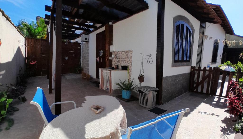 马里卡Suite Privativa Lar e Aconhego的一个带桌椅的庭院和一座房子