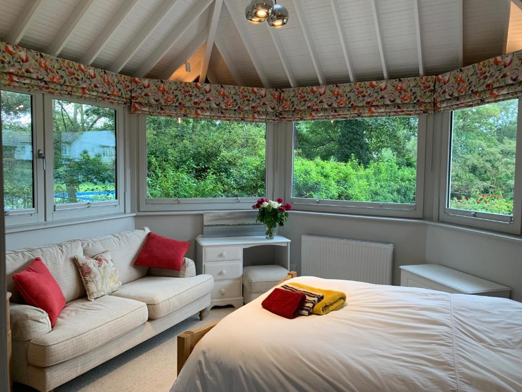 西柯比Brookfield Cottage的一间卧室配有一张床、一张沙发和窗户。