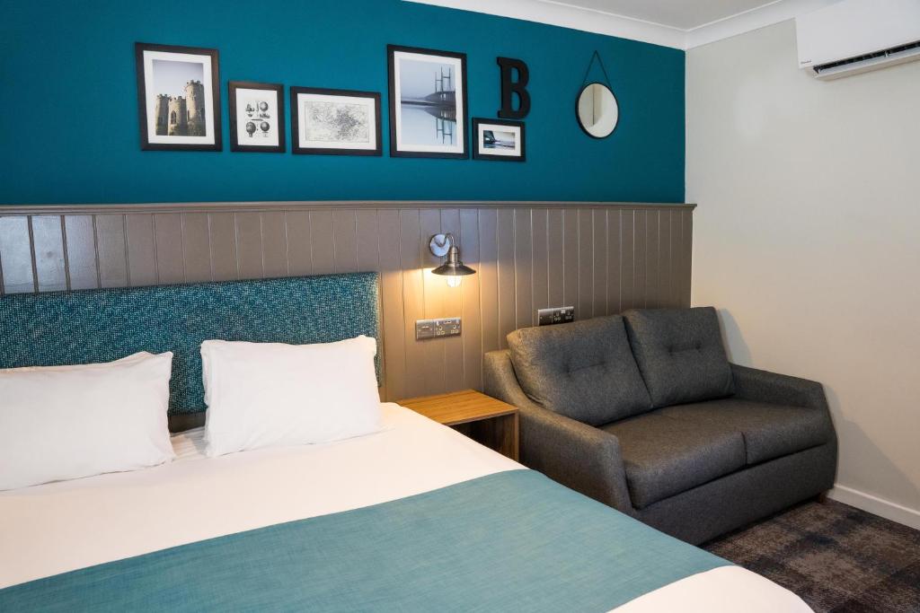 阿蒙兹伯里Almondsbury Inn & Lounge的配有一张床和一把椅子的酒店客房