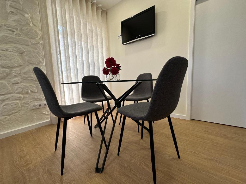 布拉加Casa da Poça 2 - Guest House的餐桌、四把椅子和电视