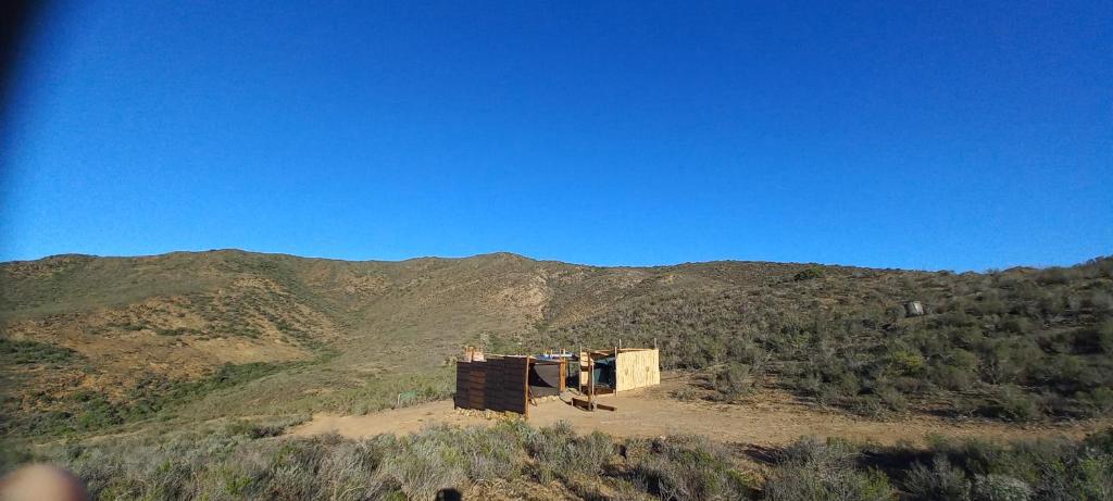 巴里代尔Cowboy's Hill - Karoo Tented Campsite with a View的山丘顶部的建筑,背景是山脉