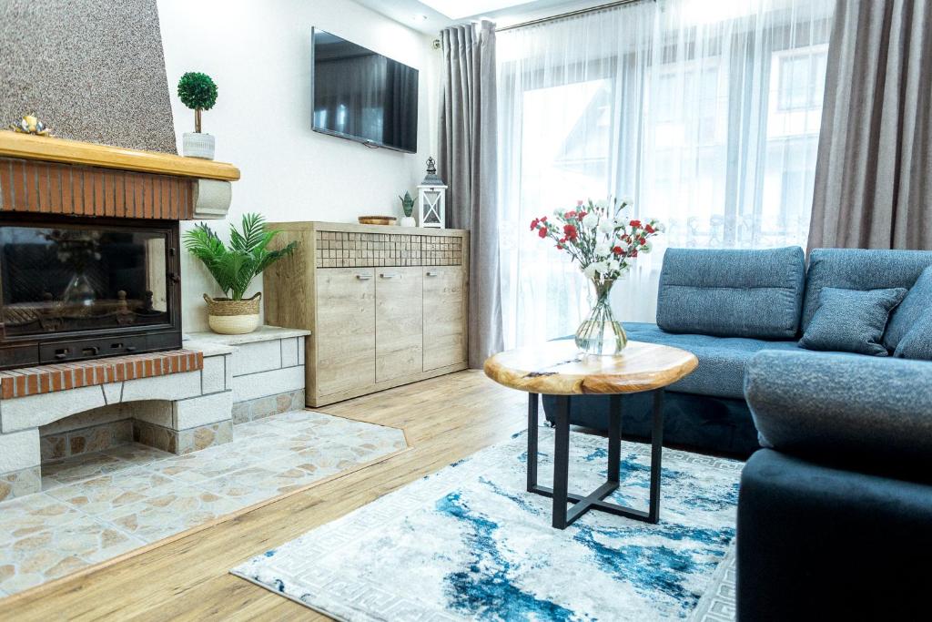 扎科帕内Pokoje Gościnne Monika III的客厅设有蓝色的沙发和壁炉