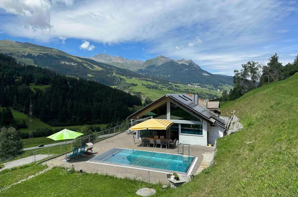 TinzenPool Villa Savognin的山丘上带游泳池的房子